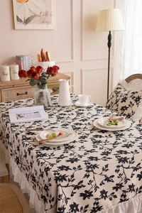 Detailed view of ruffle edges and floral print on a cream polyester rectangle tablecloth