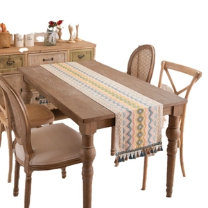 Bohemian table runner with colorful jacquard wave patterns and tassels on a wooden table