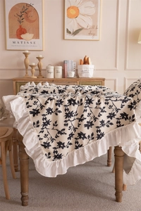 Close-up of French floral pattern tablecloth with elegant white ruffle edge detail