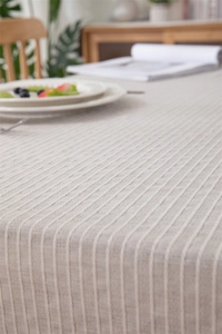 Macro view of beige cotton jacquard tablecloth showing vertical striped weave texture