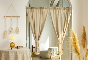Detail view of cotton striped door curtain with hanging tassels and elegant tie-backs