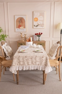 Close-up of floral polyester tablecloth featuring ruffle lace edges and vintage plant patterns