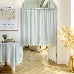 Japanese style light blue striped cotton door curtain with tassels in a bright home setting