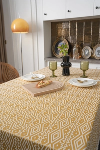 Detalle de patrón geométrico de jacquard y borlas en mantel de comedor rectangular