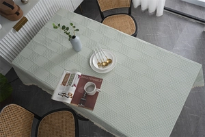 Détail d'une nappe jacquard vert menthe à carreaux avec d'élégantes bordures en dentelle