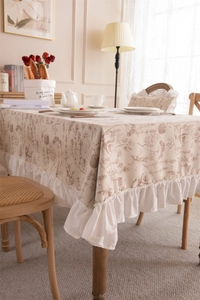 Detail of vintage floral print tablecloth with elegant white ruffled edges in French style