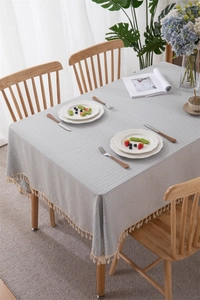 Macro detail of geometric cotton striped tablecloth with delicate tassel edge decor