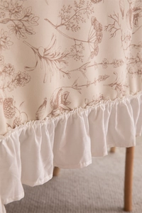 Detailed view of French vintage floral polyester tablecloth with ruffled hem edge
