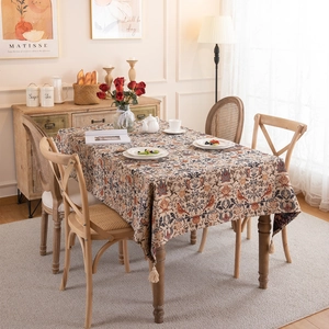 Vintage jacquard tablecloth with magpie flower pattern and tassels on wooden table