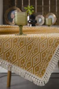 Primer plano del mantel de jacquard geométrico con patrones amarillos y flecos blancos
