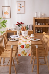 Polyester cotton table runner featuring vibrant pumpkin and sunflower harvest prints