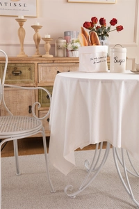 Dettaglio di una tovaglia minimalista in cotone lavato bianco con texture naturale