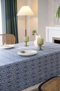 Detalle del mantel de jacquard azul geométrico con elegantes borlas de flecos blancos