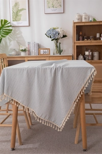 Detailed texture of blue and white striped cotton tablecloth with beige tassel fringe edge