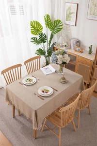 Detail of beige jacquard cotton tablecloth with vertical stripes and fringed edges