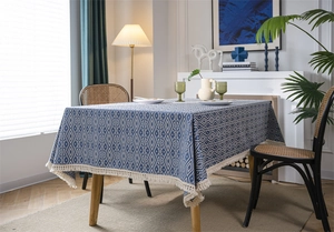 Detalle del mantel geométrico azul y blanco con bordes de flecos decorativos