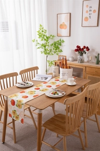 Detail of harvest pumpkin and sunflower print on waterproof autumn table runner
