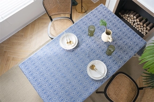 Detalle de patrón jacquard geométrico azul y blanco con flecos en el mantel de la mesa
