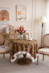 Detail of vintage bird jacquard fabric and white ruffled lotus leaf edge on round tablecloth