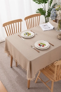 Detailed view of khaki jacquard stripe tablecloth texture with elegant tassel edges