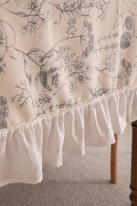 Close-up of French floral tablecloth featuring retro berry print and ruffled lace borders