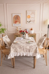 Close-up of French floral tablecloth with elegant ruffles and matching pillow details