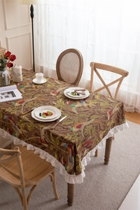 Detail of vintage floral cotton tablecloth with bird print and white ruffled edge