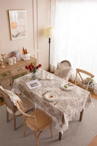 Detail of French floral tablecloth with elegant white ruffles in a cozy home setting