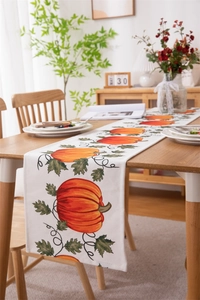 Detail of harvest pumpkin and autumn vine print on white cotton-linen table runner