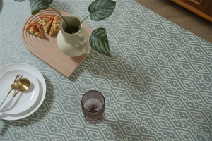 Detalle del mantel de jacquard geométrico verde salvia con textura de tejido bohemio
