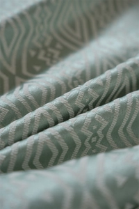 Vista macro detallada del mantel de jacquard verde menta con patrones geométricos blancos