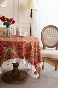 Detail of red floral cotton tablecloth with elegant white ruffled lotus leaf edges