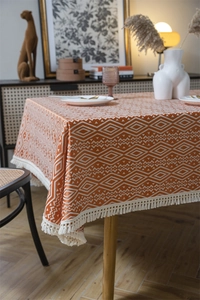 Vista detallada del mantel jacquard geométrico con bordes decorativos de borlas
