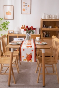 Detailed harvest pumpkin print on cotton table runner with red and black checkered edges