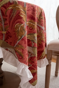 Detail of red paisley cotton tablecloth with elegant white ruffled phoenix hem design