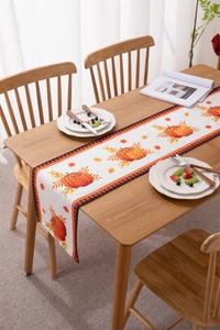 Detail of harvest pumpkin table runner with plaid edges on a rustic wooden table
