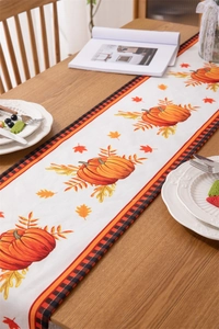 Detail of harvest pumpkin and maple leaf print on water-resistant autumn table runner