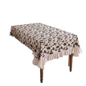 French vintage floral tablecloth with elegant ruffles on rectangular wooden table