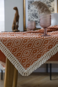 Detalle de mantel jacquard bohemio con motivos geométricos de rombos y flecos decorativos
