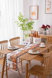 Happy Thanksgiving table runner featuring pumpkin print and black check border design