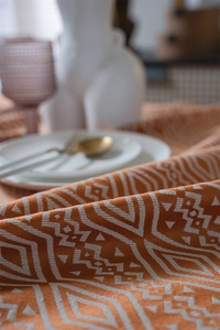 Detalle macro de la tela jacquard geométrica terracota con texturas de flecos boho