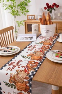 Detail of Thanksgiving table runner featuring orange pumpkins and autumn leaves pattern
