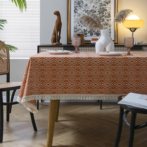 Mantel bohemio naranja con patrones de diamantes blancos y elegantes bordes de borlas