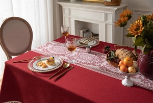 Detalle de mantel de jacquard rojo con patrones blancos retro y elegantes bordes de flecos
