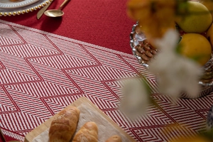 Detalle del camino de mesa jacquard geométrico rojo y blanco con textura de flecos