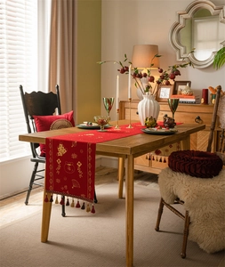 Detail of red Chinese New Year table runner with gold Fu character and tassel trim