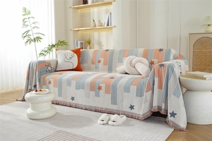 Detailed texture of chenille sofa cover featuring orange stripes and fringe tassels