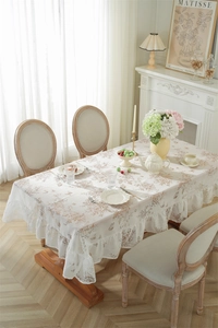 Détail de nappe en dentelle florale avec imprimés papillons et bordures à volants