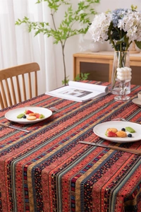 Close-up of bohemian tablecloth featuring colorful geometric stripes and golden patterns