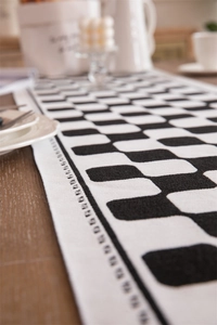 Detail of checkered table runner with black and white woven texture and side dot pattern